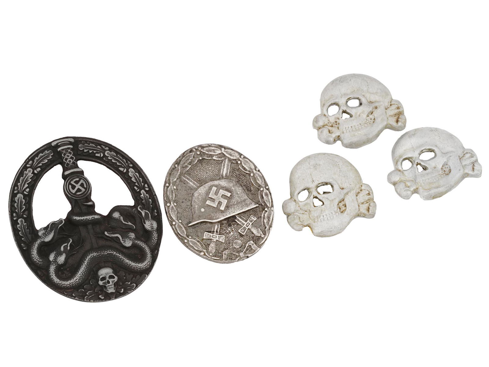 WWII NAZI GERMAN MILITARY BADGES AND VISOR CAP SKULLS: WWII Nazi German military badges. A Bandit Warfare Badge showing a skull and crossed bones at the base, with a laurel wreath of oak leaves around the sides and a sword in the center, with the swords h