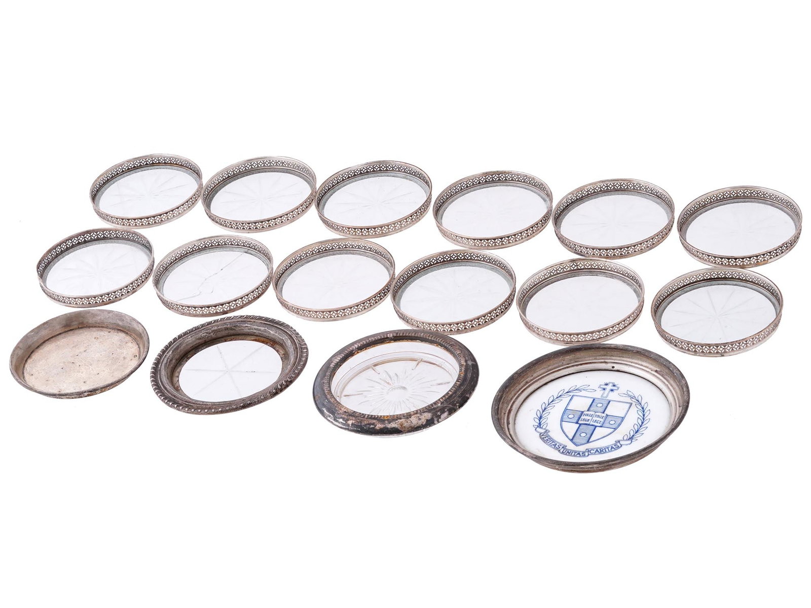 ANTIQUE AND VINTAGE ROUND STERLING SILVER COASTERS: A collection of 16 antique and vintage round sterling silver coasters. Crafted with meticulous attention to detail, each coaster features a lustrous sterling silver rim that beautifully frames the ele