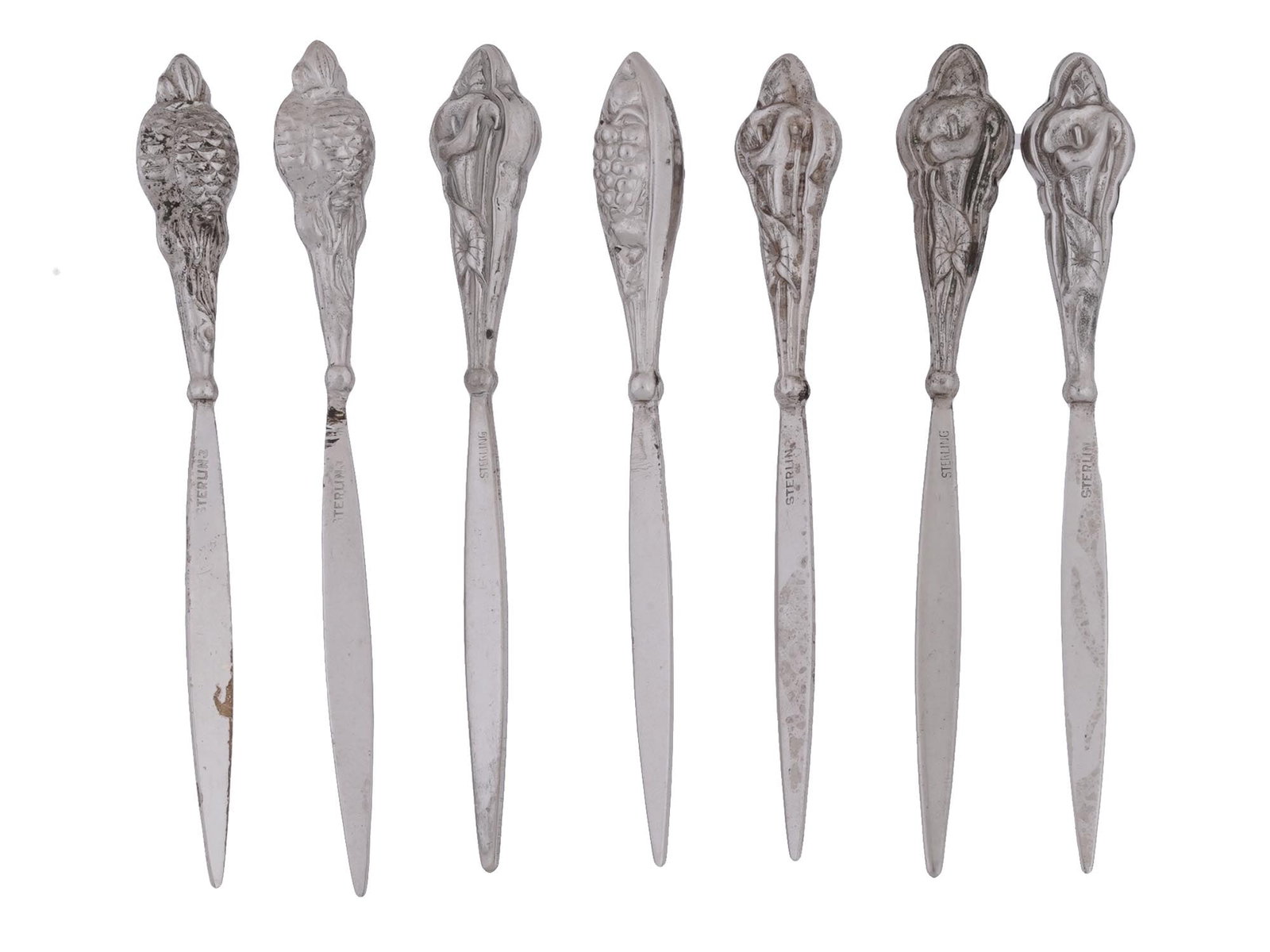 VINTAGE STERLING HORS D OEUVRE COCKTAIL PICKS: A lot of vintage sterling silver cocktail picks with relief tip design, including pineapple, grape, lily. A total of 7 items. Each piece is marked Sterling. Total Weight: 34 grams. Collectible Silverw