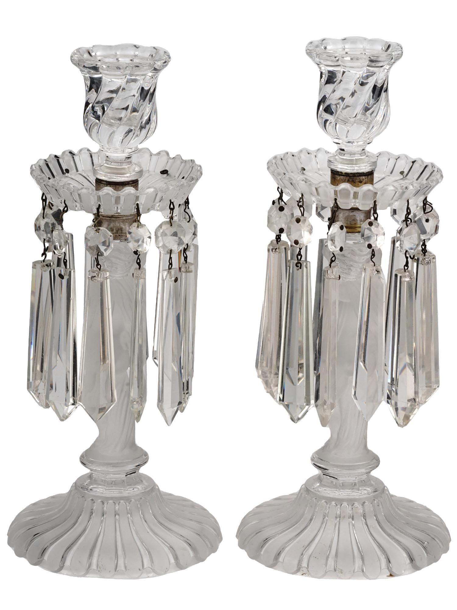 BACCARAT CRYSTAL ZENITH CANDELABRA WITH PENDANTS: A pair of clear crystal candlesticks by Baccarat, a French manufacturer of fine crystal. Zenith model. Aluminum base. Frosted glass female nude figurines serve as stems. Each candle holder has two det