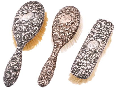 CLUNY BY GORHAM STERLING HAIR AND CLOTHES BRUSHES: A matching set of three antique late 19th-century American sterling silver brushes by Gorham Silver. A total of two handled hair brushes and a clothes brush. Cluny pattern, repousse floral decor with