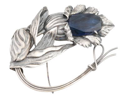 ATTR TO GEORG JENSEN ART DECO SILVER BLUE STONE BROOCH: A vintage Danish Art Deco sterling silver flower shaped brooch attributed to Georg Jensen and adorned with a blue stone. Georg Jensen, a renowned Danish silversmith, was known for his distinctive desi