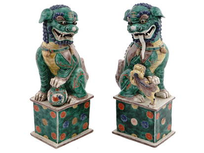 PAIR OF LARGE ANTIQUE CHINESE FOO DOG FIGURINES: A pair of antique Chinese finely modeled and polychrome-glazed ceramic statues representing foo dogs. Late Qing dynasty, before 1912. One figure represents a male lion with a temari ball and the other
