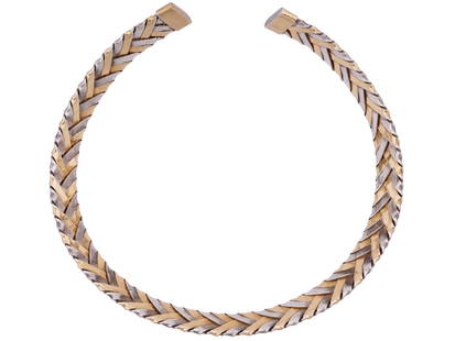 CARTIER 18K GOLD STERLING SILVER BANGLE BRACELET: A vintage bicolar open-bangle bracelet made of 18K yellow gold and sterling silver by Cartier. Woven or braided design. Marked Cartier, 18K, 925 on the tips. Total Weight: 65 grams. Collectible Elegan