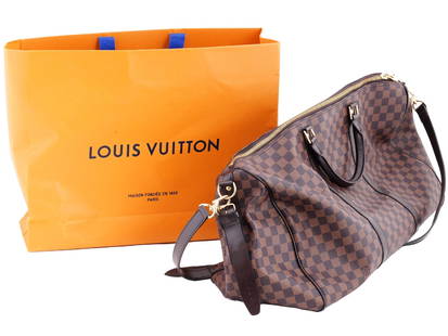 LOUIS VUITTON DAMIER EBENE KEEPALL BANDOULIERE BAG: A Louis Vuitton Damier Ebene Keepall Bandouliere 45 bag. The duffel bag is crafted of damier checkered coated canvas with dark brown leather accents. It features rolled leather top handles, a detachab