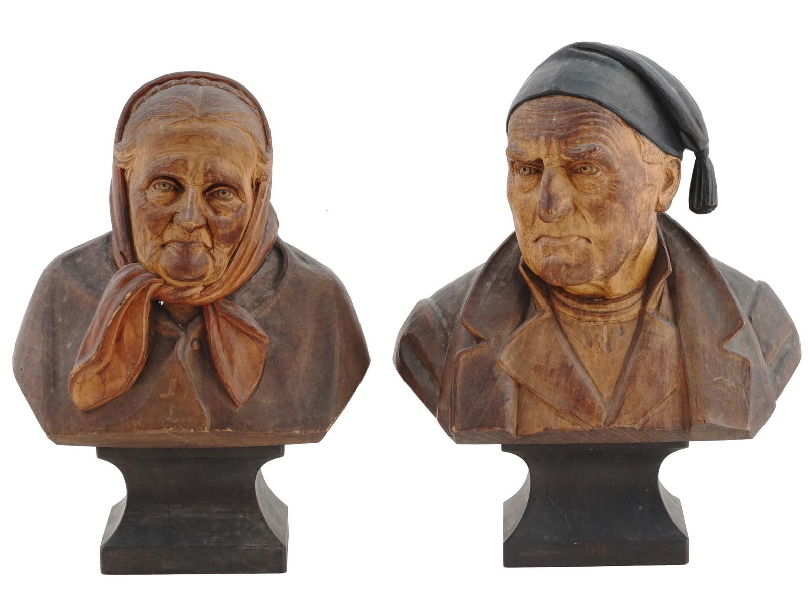 ATTR TO HANS HUGGLER WYSS ANTIQUE CARVED WOOD BUSTS: A pair of antique European, probably Swiss, hand carved wooden busts attributed to Hans Huggler Wyss, Swiss, 1877 to 1947. The polychrome hand colored busts depict an old man and a woman. The facial f