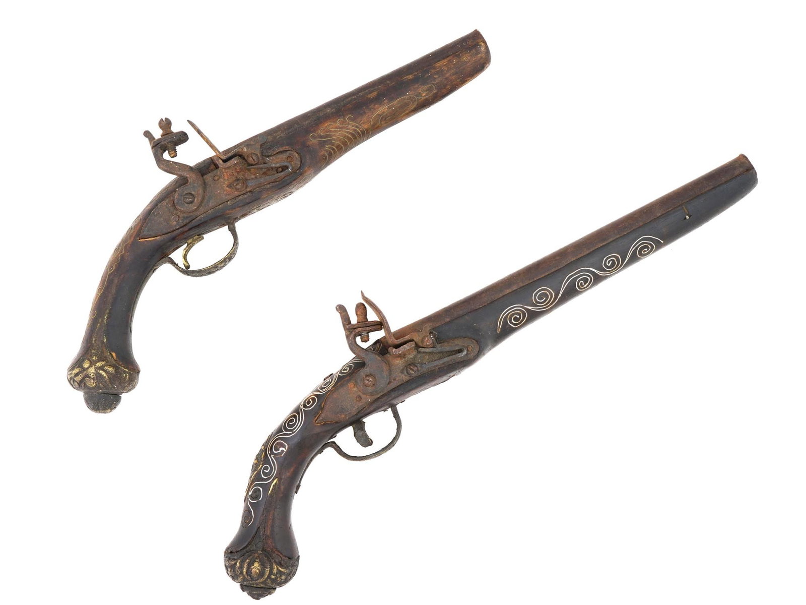 ANTIQUE INDIAN MUGHAL SILVER INLAID FLINTLOCK PISTOLS: A pair of antique 18th to 19th century decorative flintlock pistols. Presumably of Indian origin, late Mughal Empire era. Steel barrels with walnut wood stock, brass cut caps. The bigger pistol is inl