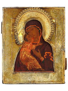 ANTIQUE RUSSIAN ORTHODOX THEOTOKOS OF VLADIMIR ICON: An antique Russian Orthodox hand painted Theotokos of Vladimir icon. Tempera on a wooden panel with a gilt silver oklad. The icon depicts Jesus Christ as a child being held in the arms of his mother,