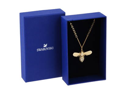 SWAROVSKI NECKLACE W CRYSTAL BUMBLE BEE PENDANT IOB: A Swarovski Lisabel crystal costume jewelry necklace. The necklace features a bumble bee figural pendant on a gold plated chain with honeycomb shaped links. The pendant is encrusted with clear and bla