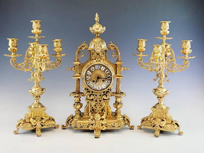 ANTIQUE 19C FRENCH GILT BRONZE CLOCK CANDELABRA SET: A large antique 19 century French gilt bronze garniture or mantel set. The set includes a mantel clock and pair matching candelabra. The pair of five light candelabras are raised on a heavy ornate bas