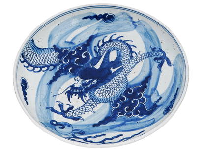 ANTIQUE CHINESE DRAGON BLUE AND WHITE PORCELAIN BOWL: An antique Chinese, late Ming dynasty, blue and white porcelain bowl. The interior of the bowl is adorned with an image of a dragon surrounded by a cloud motif. The exterior of the bowl is decorated w