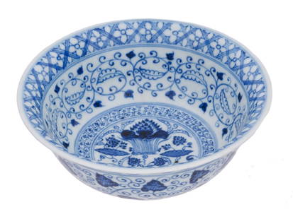 CHINESE MING DYNASTY BLUE AND WHITE PORCELAIN BOWL: An antique Chinese, late Ming dynasty, blue and white porcelain bowl. The interior of the bowl is adorned with an image of a still life with flowers, surrounded by floral, foliage, and geometrical pat