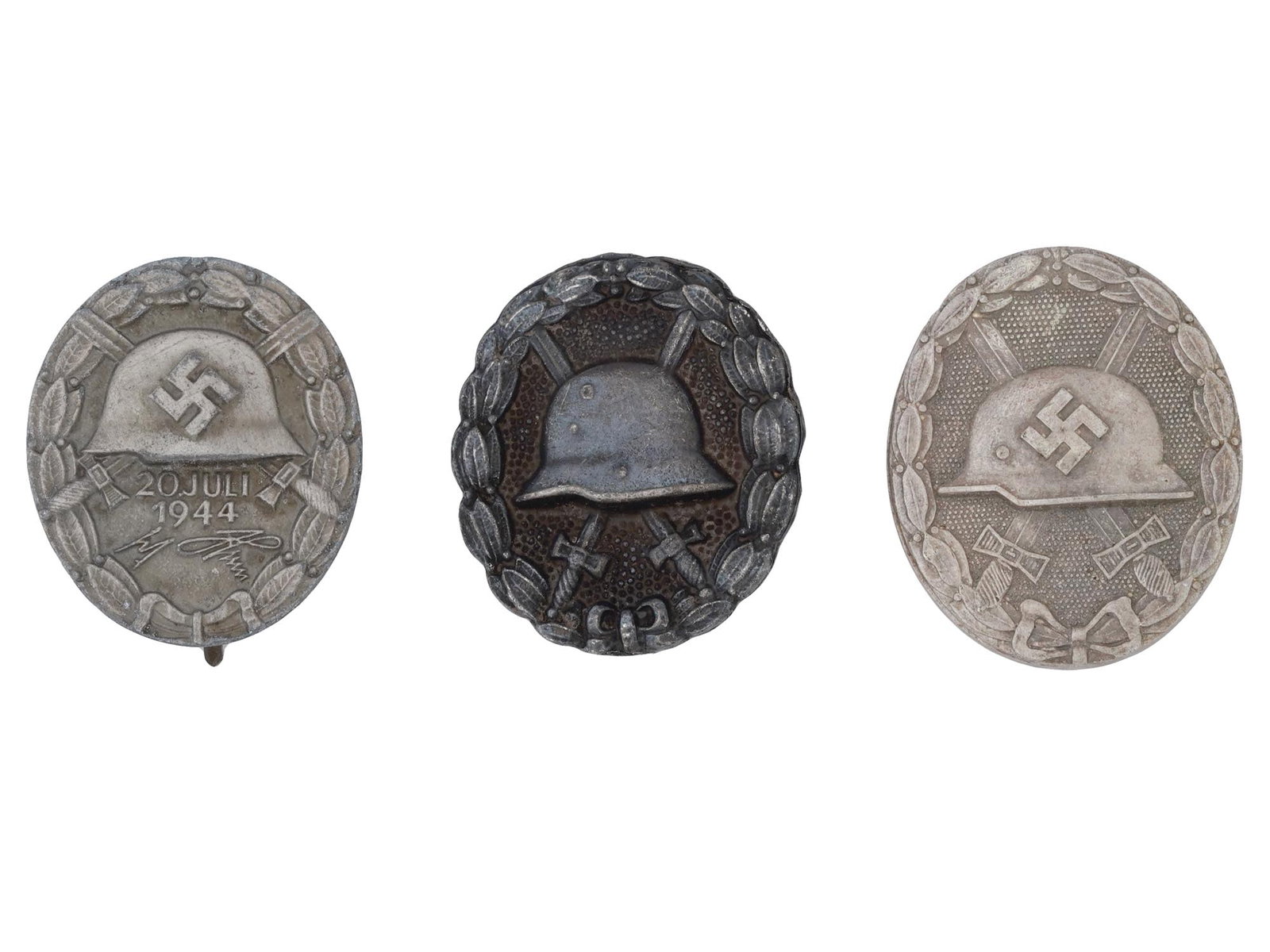 GROUP OF 3 GERMAN WOUND BADGES WWI AND WWII: A group of three German wound badges from World War I and World War II. First is the 20th of July 1944 silvered wound badge. This item follows the design of the typical wound badge with the swastika, 