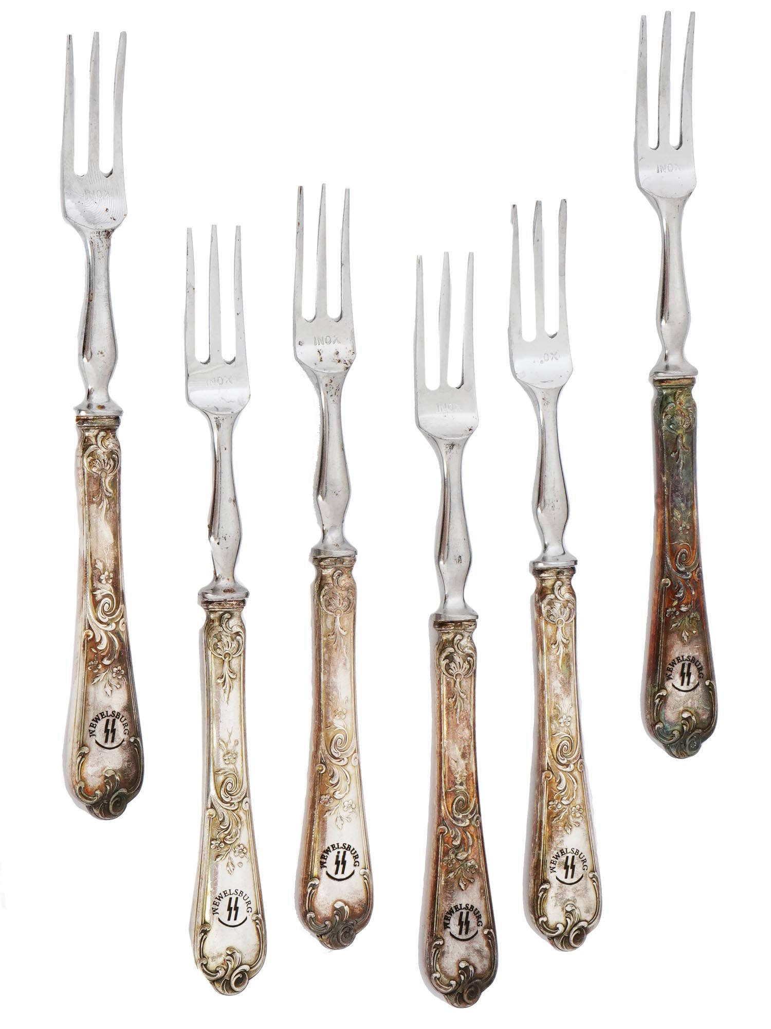 SET OF 6 DESERT FORKS FROM THE SS ACADEMY WEWELSBURG: A set of World War II stainless steel sugar desert forks from the SS Academy canteen in Wewelsburg. A total of six items. The handles of the forks are adorned with an embossed scrollwork motif. Each f