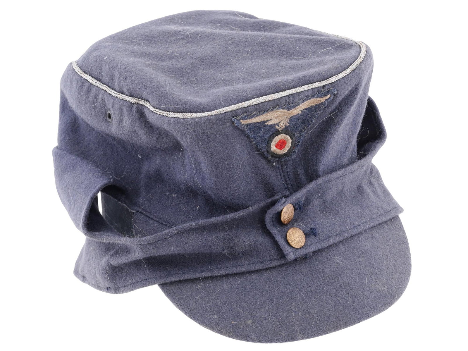 WWII NAZI GERMAN LUFTWAFFE PEAKED WOOL FIELD CAP: A World War II Nazi German Luftwaffe officers peaked field cap made of blue wool. Reichsadler with swastika patch on the front. Label Willy Sprengfeil Mutzenfabrik Hamburg 19, 58 is on the inner side 