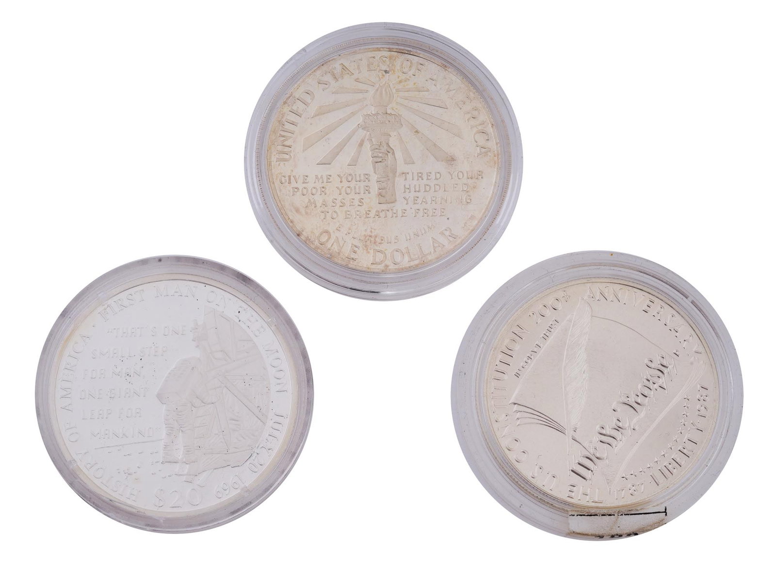 LIBERIAN AND AMERICAN COMMEMORATIVE SILVER COINS: A trio of remarkable silver coins including a Republic of Liberia 2001 First Man on the Moon 20 dollar coin, an American 1986 Statue of Liberty on Ellis Island one dollar coin, and an American 1987 20