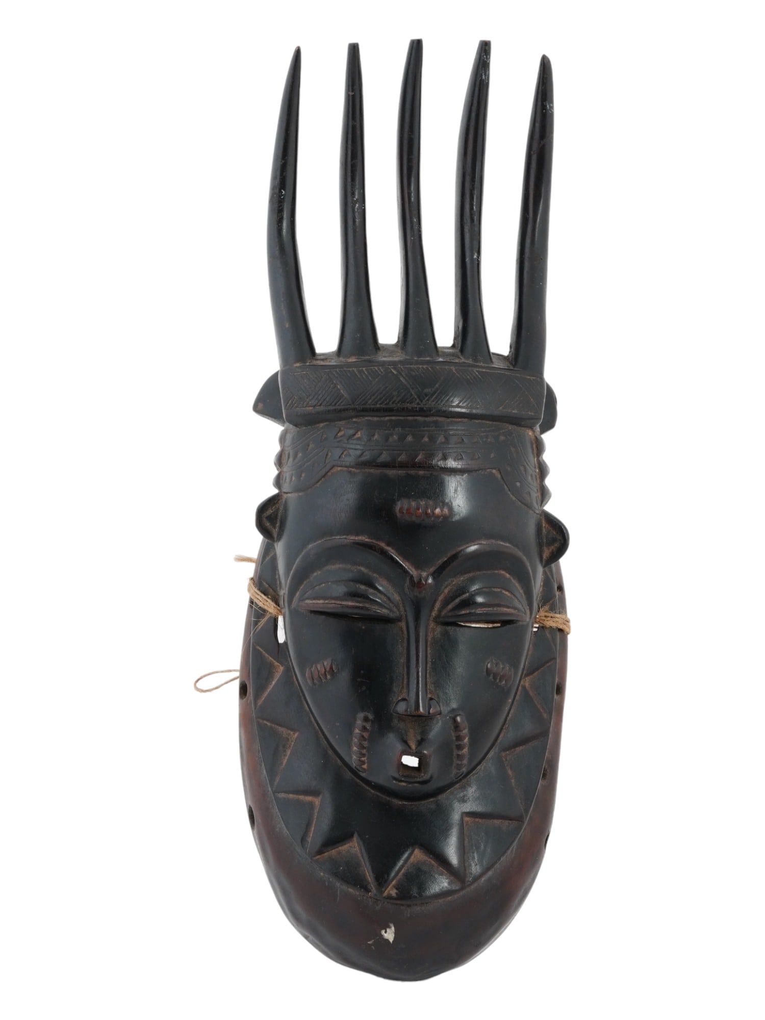 DARK BAOLET MASK FROM IVORY COAST WEST AFRICA: A dark Baolet mask from West Africa, Ivory Coast. The mask is modeled with narrow eyes, a small mouth, five horns and a wide collar that completely covers the neck. Provenance: New York, Private colle