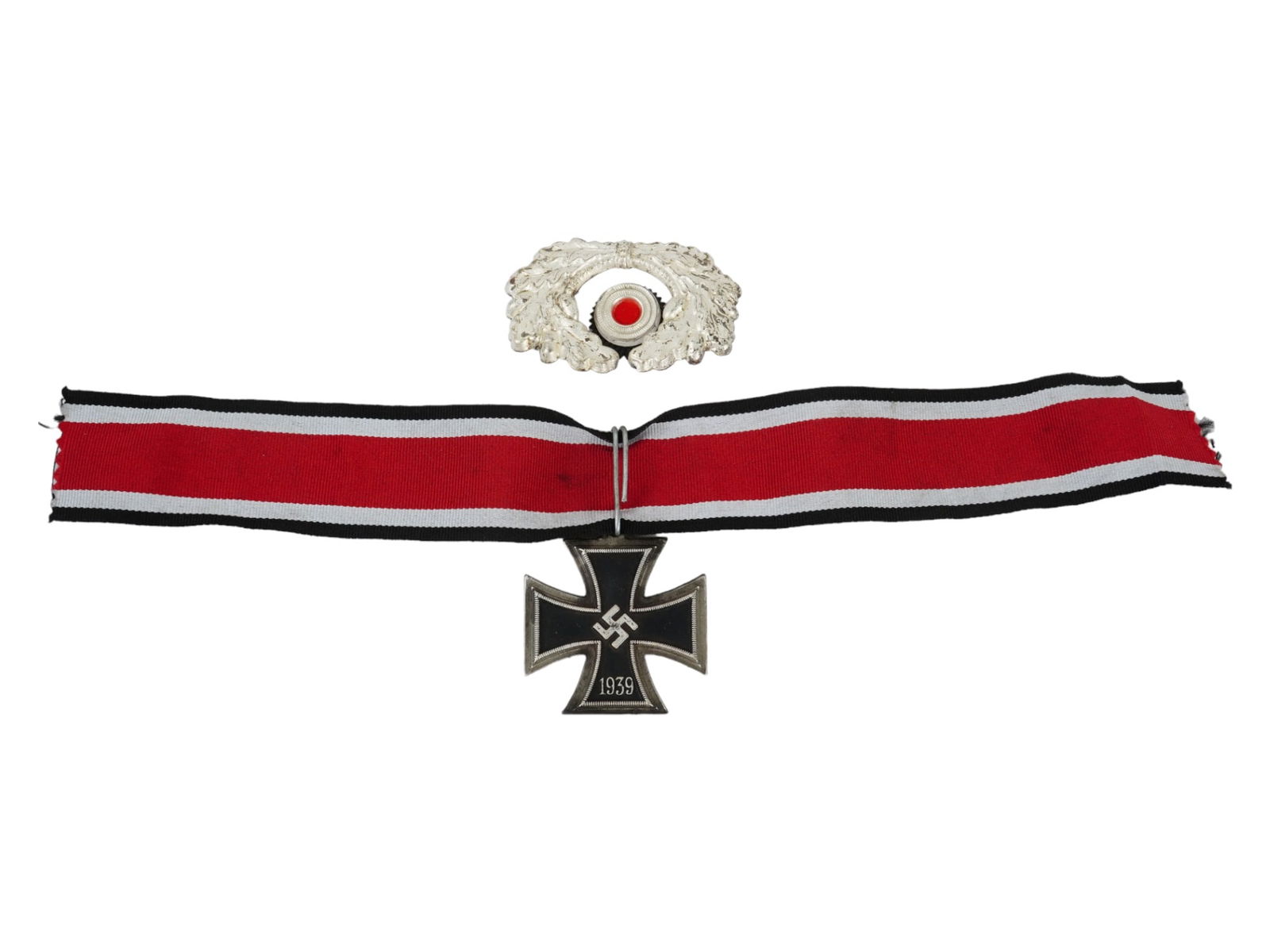 WWII NAZI GERMAN THIRD REICH MILITARY BADGES: A lot of two Nazi German items. The first is the black Iron cross featuring the swastika emblem and the date 1939 on the front side, and the date 1813 on the backside, comes with a ribbon. The Iron Cr