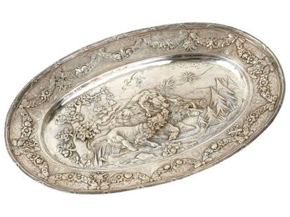 ANTIQUE AMERICAN EMBOSSED SILVER PLATED SERVING TRAY: An antique early 20th-century American silver-plated serving dish or fruit bowl. The borders are embossed with rose flower garlands and ribbons. The central part depicts a hunting scene, two wolves ki