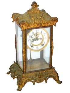 ART NOUVEAU AMERICAN ANSONIA GILT BRONZE MANTLE CLOCK: An American Art Nouveau manner mantel clock manufactured by Ansonia Clock Company. A white enameled dial with black Arabic numerals and hands. The gilt body is adorned with a relief foliage motif and