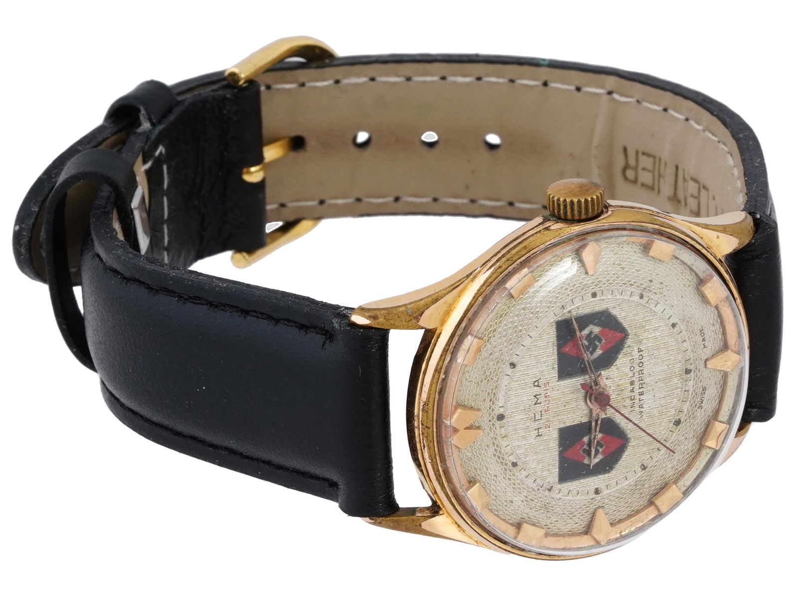 GERMAN WWII HITLER YOUTH WRIST WATCH: A 1930s to 1940s Nazi German gilt stainless steel incabloc wristwatch by Hema. Round case, single crown. Guilloche dial with dagger and baton indexes, decoareted with two Hitler Jugend emblems, marked