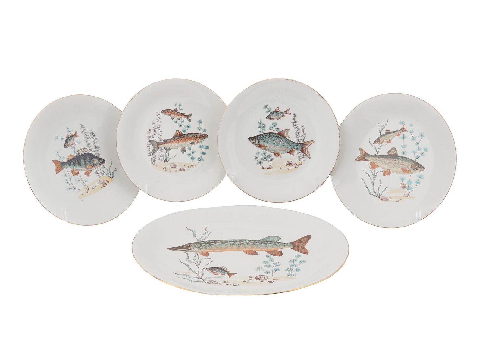 VINTAGE POLISH CMIELOW PORCELAIN FISH SERVEWARE: A vintage Polish porcelain serveware set including four plates and a serving dish. Each of the pieces has a unique painted fish scene with a gilt rim. Marked on verso Cmielow. Circa the 1950s. Vintage