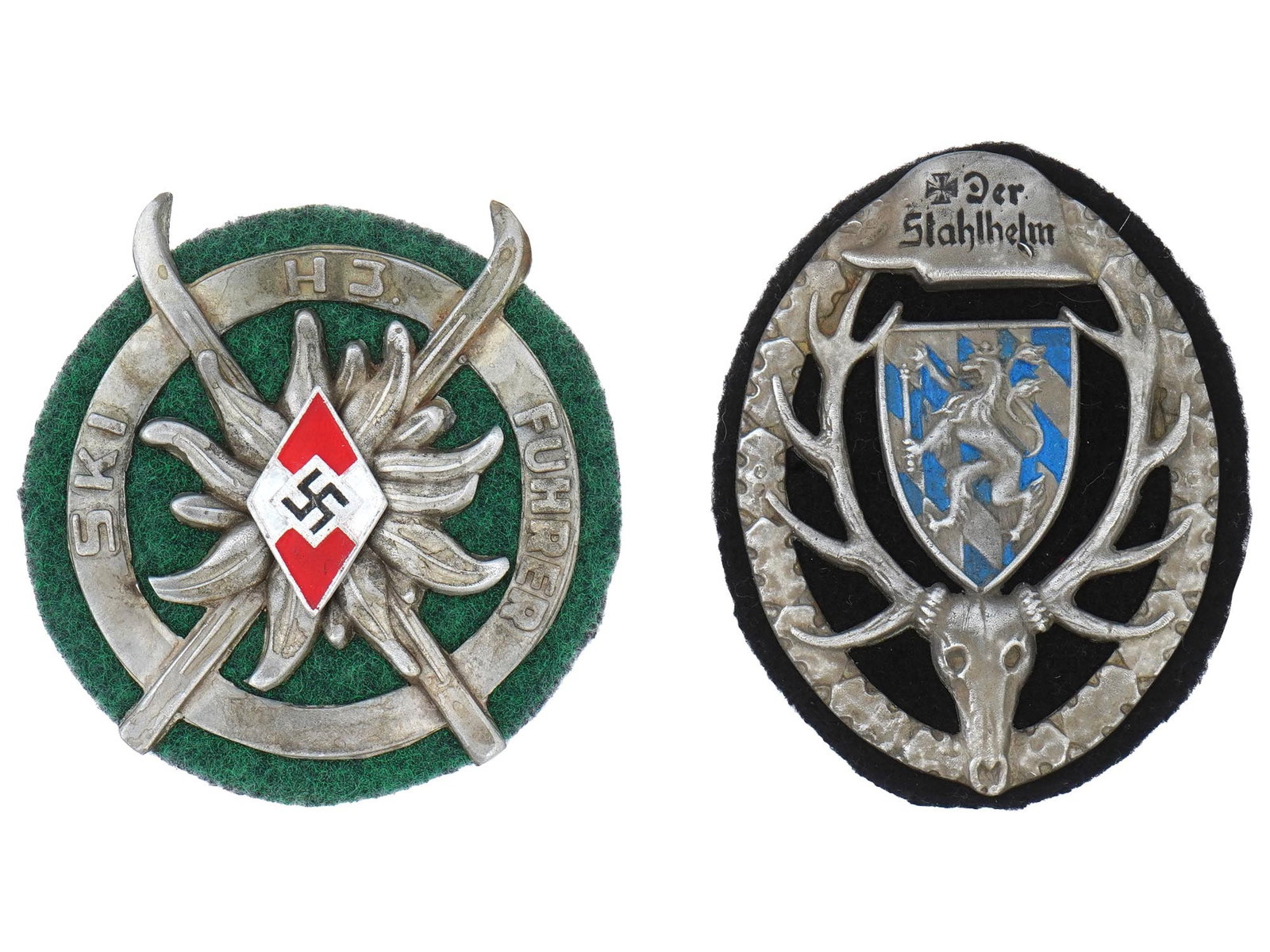 GROUP OF TWO GERMAN THIRD REICH PERIOD SHIELD BADGES: A lot of two WWII Nazi German Third Reich era shield badges. The lot includes a Nazi Hitler Youth Ski Fuhrer badge, adorned with an engraved image of an Edelweiss flower, and a pin with a swastika ins