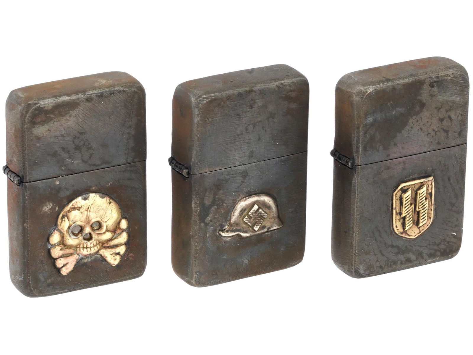 THREE WWII NAZI GERMAN GAS LIGHTERS ZIPPO 1944: A lot of three WWII Nazi German metal gas lighters Zippo 1944. All gas lighters have an applied relief gilded decor, in the form of a Totenkompf skull, a helmet with a swastika, and the SS symbol in t