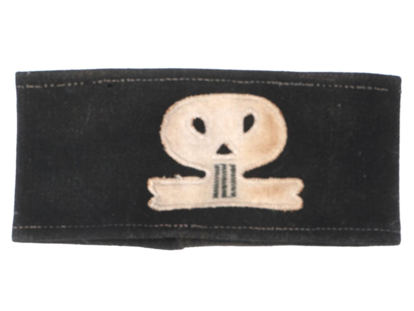GERMAN WWII SKULL SHOCK TROOPER ARM BAND: A Pre WWII Nazi German Skull Shock Trooper cotton arm band. The arm band is adorned with a patch depicting a skull. Embroidered with white stitched on the borders. The reverse of the armband has a mac