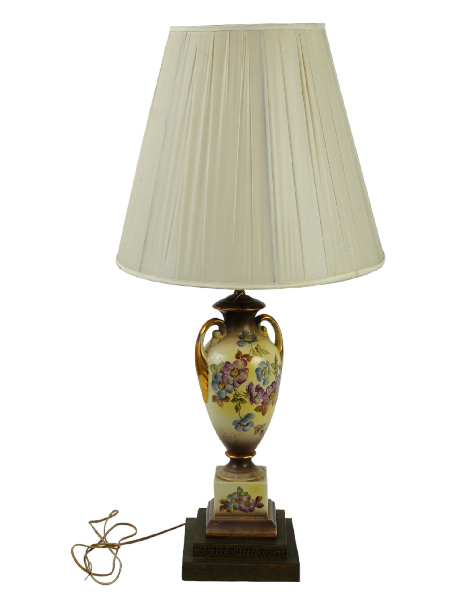 EUROPEAN GILT HAND PAINTED PORCELAIN LAMP W SHADE: A vintage European porcelain lamp with a shade. The body of the lamp is made in a shape of an amphora shaped vase with handles, adorned with hand painted blossoming flowers, and gilded accents. Mounte