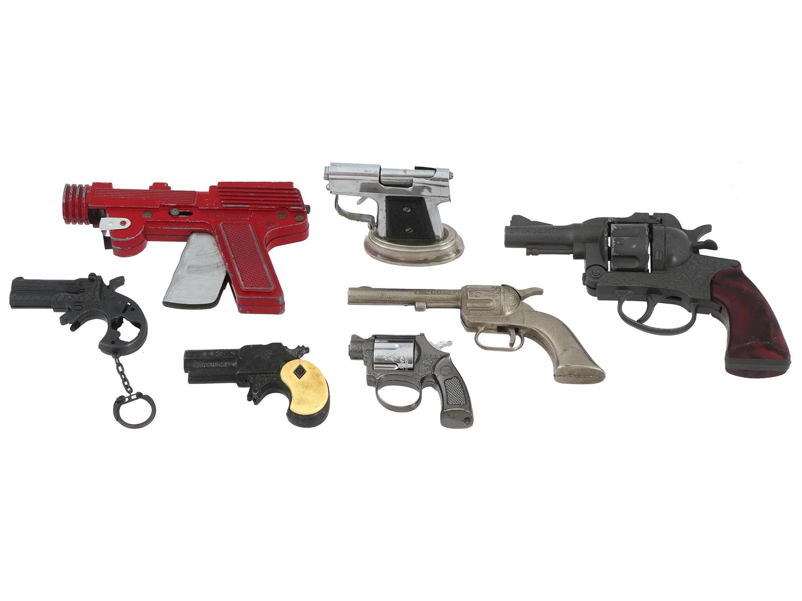 SEVEN VINTAGE TOY GUNS WITH UNIQUE DESIGNS: A collection of seven vintage toy guns, each featuring unique designs. These toy guns provide a nostalgic glimpse into historical playthings. Each gun, with its distinct design, represents a piece of 