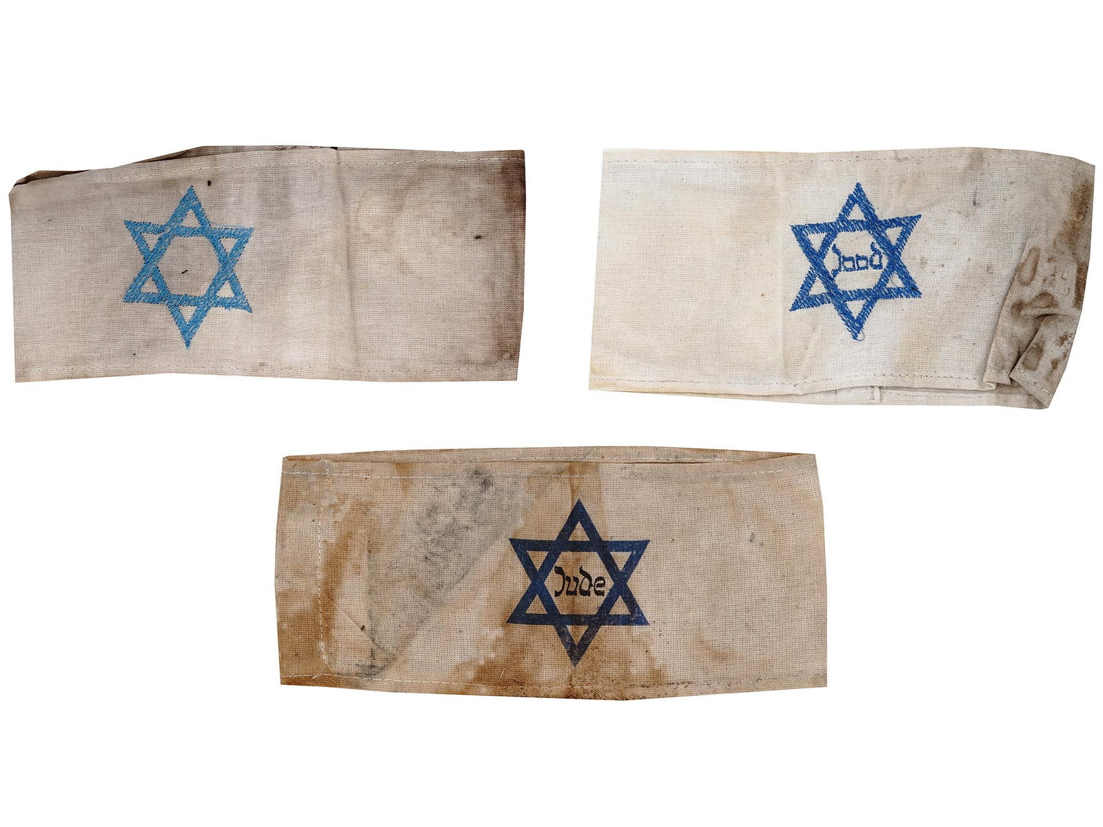 WWII HOLOCAUST JEWISH GHETTO ARMBANDS 3 PCS: Three World War II Jewish ghetto armbands. A pair of armbands with a hand embroidered Magen David, one has the inscription Jew in Dutch. The third has a printed Magen David with the inscription Jew in