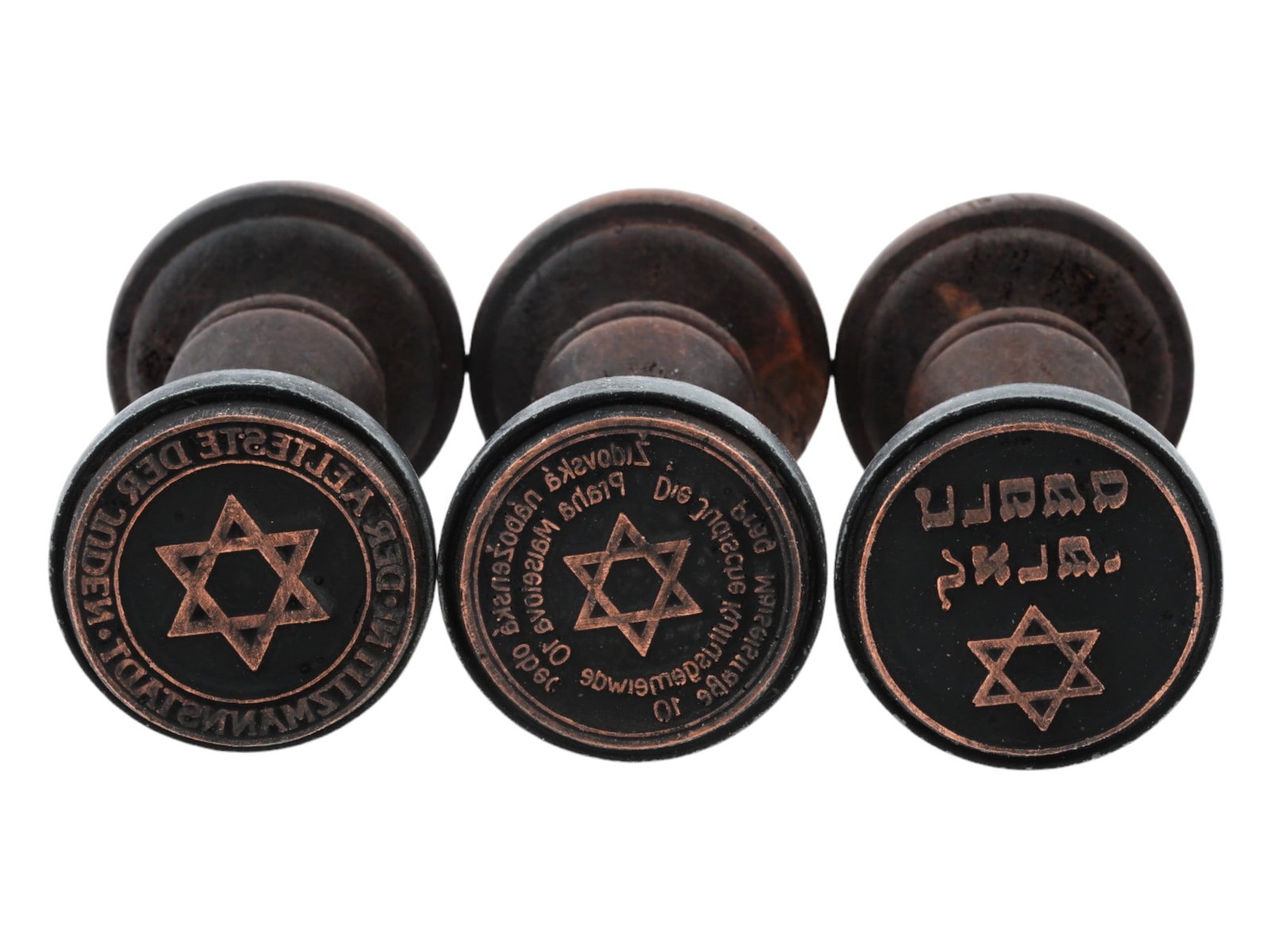 THREE HOLOCAUST PERIOD JEWISH GHETTO HAND STAMPS: A lot of three World War II model Polish wooden hand stamps of ghetto administrations. Der Aelteste der Juden in Litzmannstadt, Council of Elders of the Jewish Ghetto in Lodz. Zidovska Nabozenska Obet