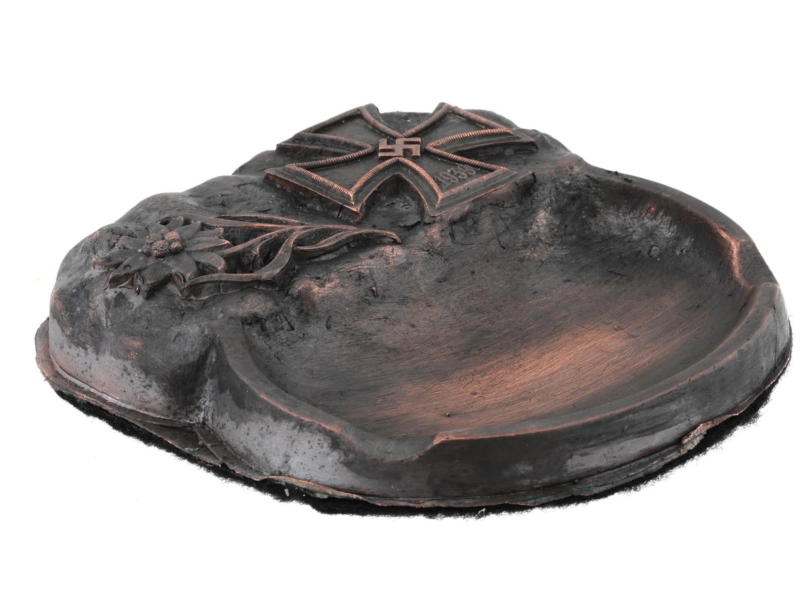 GERMAN WWII TYPE MOUNTAIN TROOPS ASHTRAY: A WWII Nazi German Third Reich Mountain Troops patinated metal ashtray. The ashtray features relief images representing an Edelweiss flower insignia, and an Iron Cross featuring a swastika insignia in