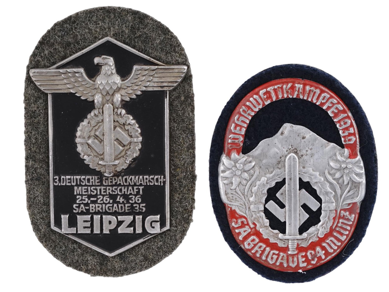 WWII GERMAN NAZI THIRD REICH MILITARY PIN SHIELDS: A pair of WWII German Nazi Third Reich Military pin shields. Made of aluminium. The first: a 1939 SA Brigades Military Competitions in Linz white and red enameled shield, decorated with an engraved Ed