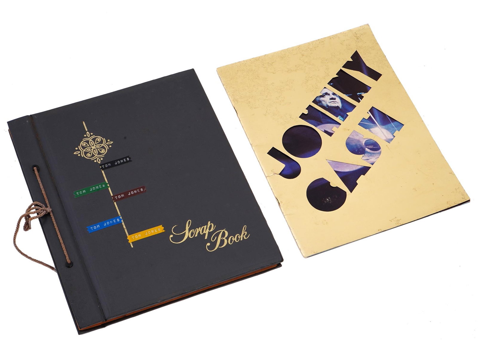 1975 JOHNNY CASH TOUR BOOK AND TOM JONES ALBUM: A lot of musicians memorabilia. A 1975 Johnny Cash souvenir tour book with color illustrations. A 1970s-1980s scrapbook with a collection of black and white photographs of Tom Jones, as well as a 1972
