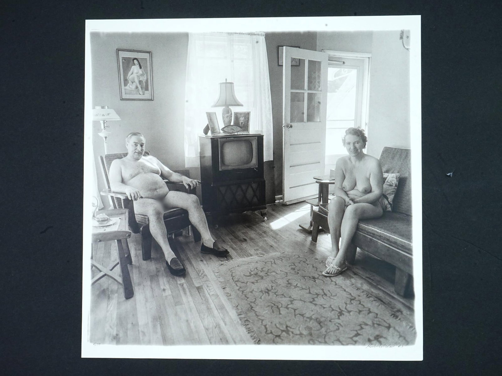 PHOTOGRAVURE AFTER DIANE ARBUS MAN AND HIS WIFE 1963: After Diane Arbus, American, 1923 to 1971, a photogravure of the original print showing a retired man and his wife at home in a nudist camp one morning, N.J., 1963. Signed and dated lower right. Numbe