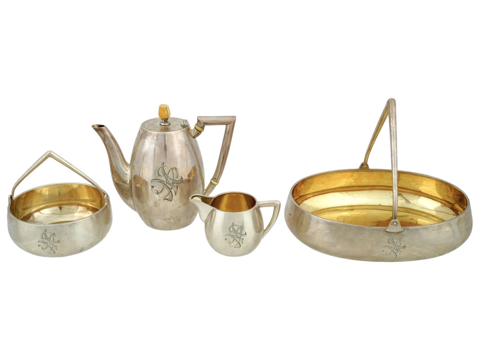 ANTIQUE RUSSIAN SILVER COFFEE SET BY GRACHEV BROS: An Imperial Russian silver four-piece coffee set by Grachev Bros. The set includes a coffee pot, a creamer, a sugar basket, and a basket serving tray. Gilt interior. Each item has an engraved DM monog