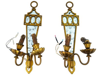 GILBERT POILLERAT FRENCH ORMOLU WALL LIGHT FIXTURES: A pair of Louis XVI style vintage French wall light fixtures by Gilbert Poillerat, French, 1902 to 1988. The fixtures are designed as ormolu mounted mirrors with two candle modeled sockets. Each is ma