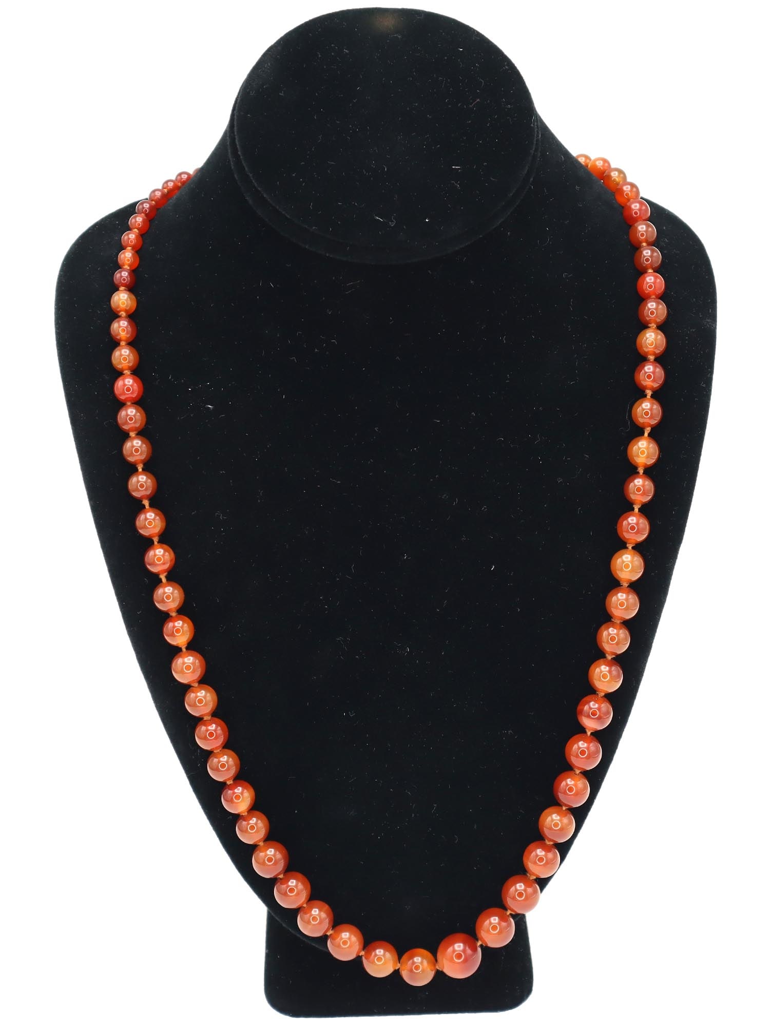 VINTAGE CARNELIAN STONE GRADUATED BEADED NECKLACE: A vintage hand-knotted beaded necklace made of carnelian stone beads. The bead size enlarges towards the front. Costume Jewelry For Women, Mineral Stone Jewelry. Dimensions: L 27 1/2 in. All measureme