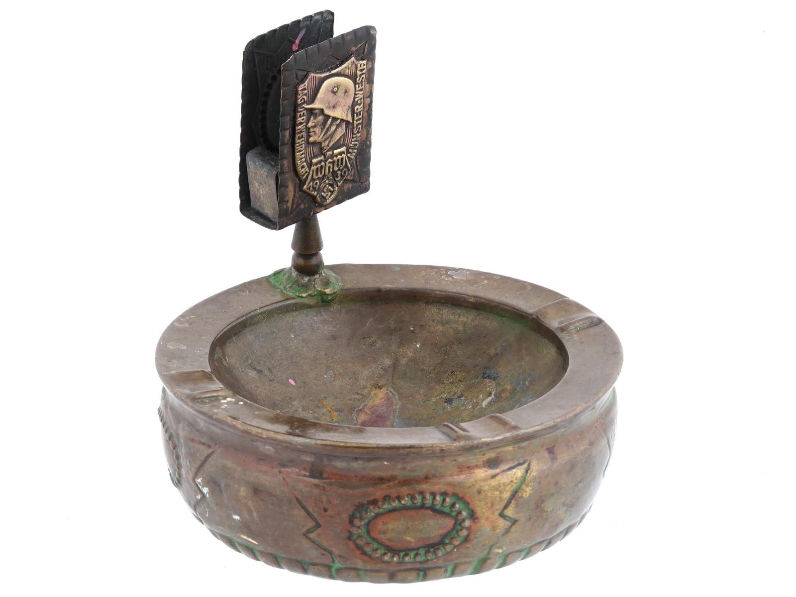 WW II LARGE NAZI GERMAN ASHTRAY W MATC HOLDER: A WW II model large Nazi German metal military deep ashtray with a match holder. Deep round ashtray with three grooves for cigarettes and relief decor on the exterior surface. A match holder with a re