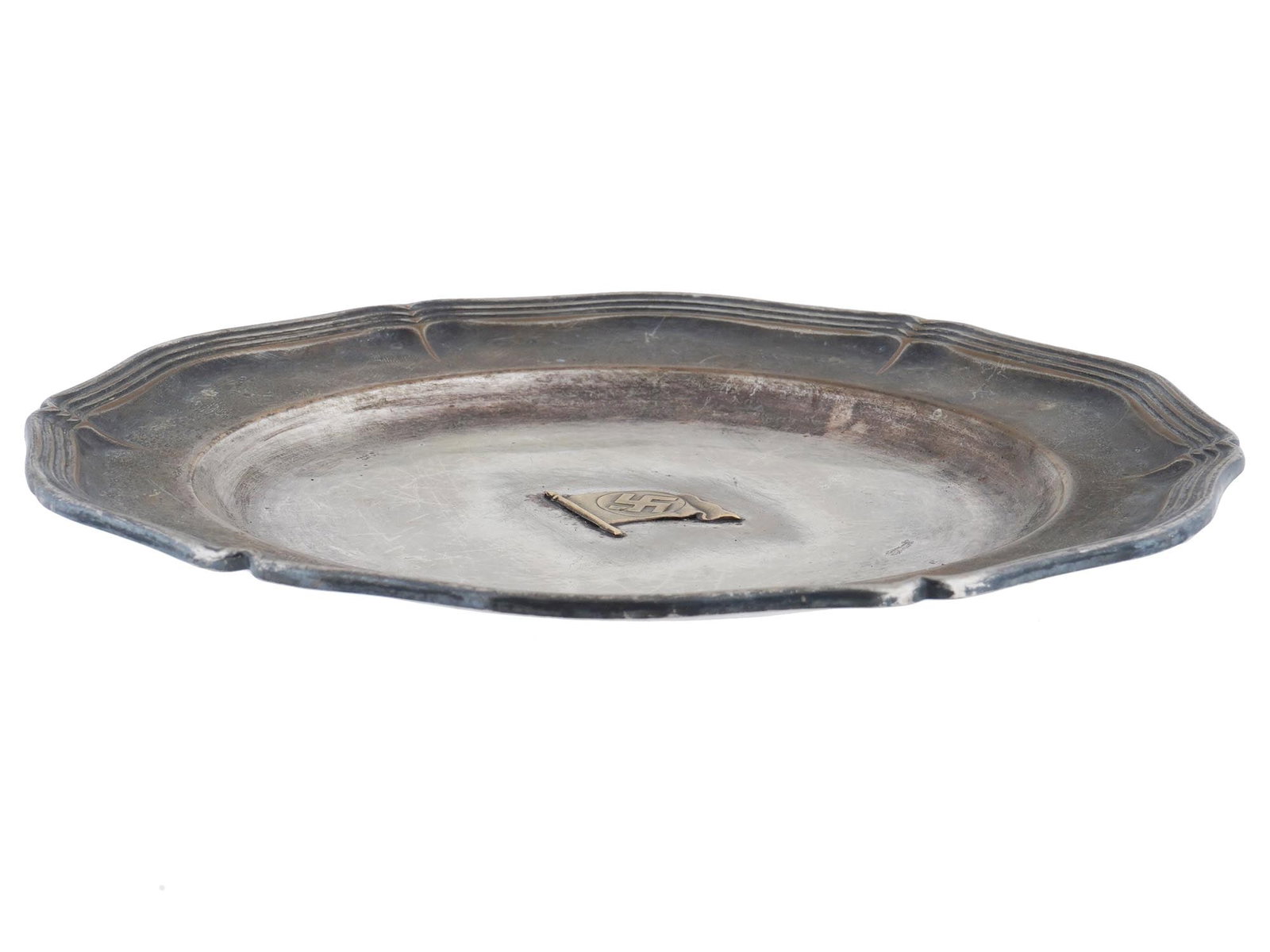 WWII NAZI GERMAN TYPE SWASTIKA INSIGNIA METAL PLATE: A WWII Nazi German Third Reich era type metal bowl or plate. The interior of the dish is decorated with a relief gilded design depicting Sa flag with a swastika insignia. Marked with a Nazi eagle 195 
