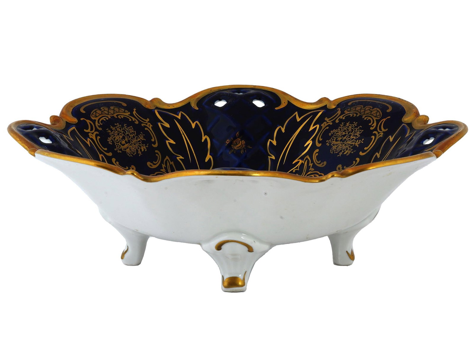 GDR REICHENBACH COBALT BLUE PORCELAIN CENTERPIECE: A mid-20th century East German porcelain centerpiece by Reichenbach Porzellan, a German porcelain manufacture. Footed white bowl, figurative rim with pierced decor, cobalt blue interior, gilt floral o