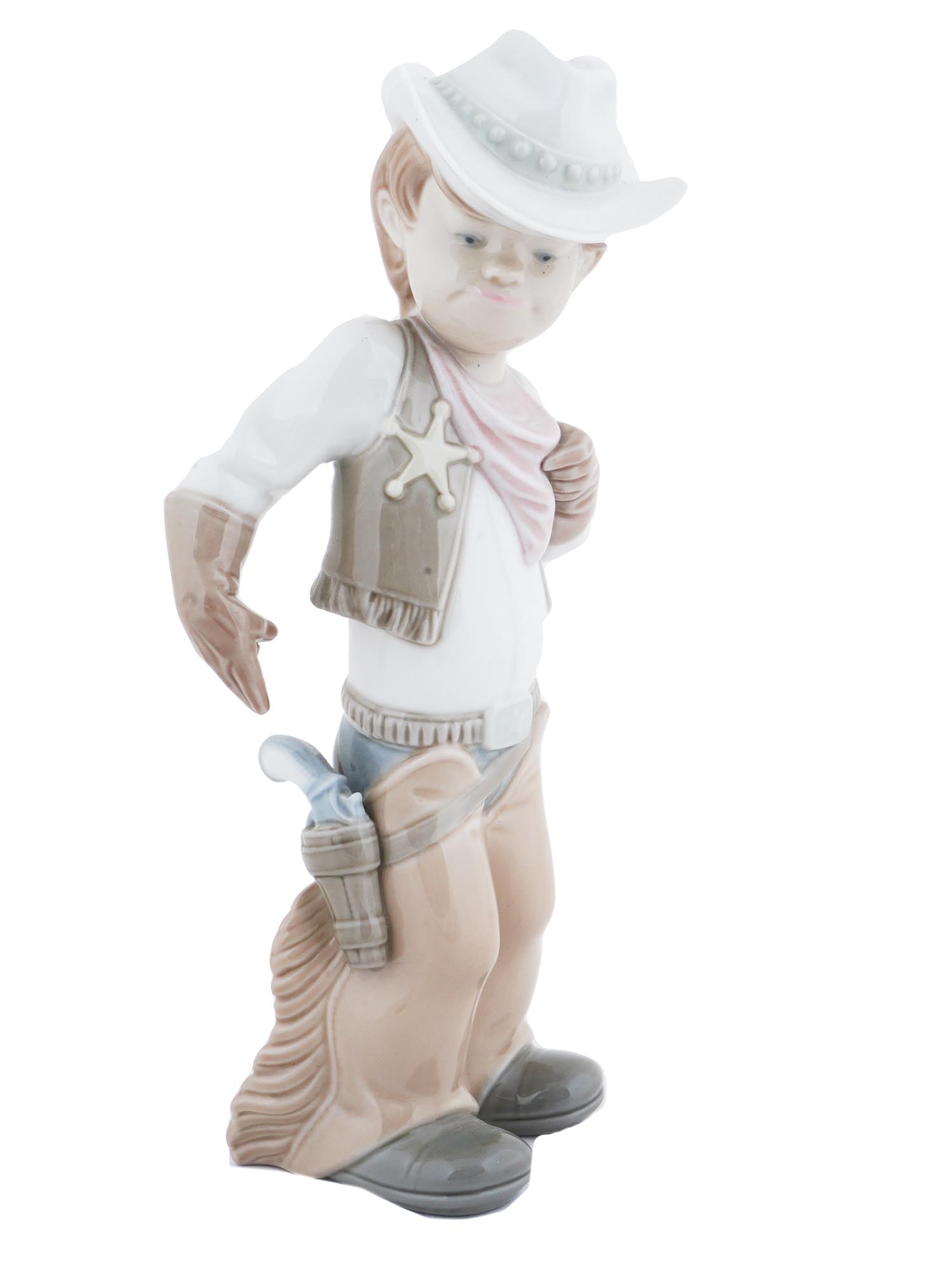 SPANISH LLADRO PORCELAIN YOUNG COWBOY FIGURINE: A vintage hand painted porcelain Young Cowboy figurine by Lladro, a Spanish porcelain manufacturer. The porcelain figurine represents a boy playing a cowboy, ready to grab a toy gun from his holster. 