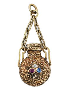 ANTIQUE 14 K GOLD RUBY DIAMOND SAPPHIRE BOTTLE CHARM: An antique Victorian 14K gold perfume bottle, circa the mid 19th century. The piece is modeled as a miniature vessel of a round shape, adorned with finely detailed hand carved floral patterns and set