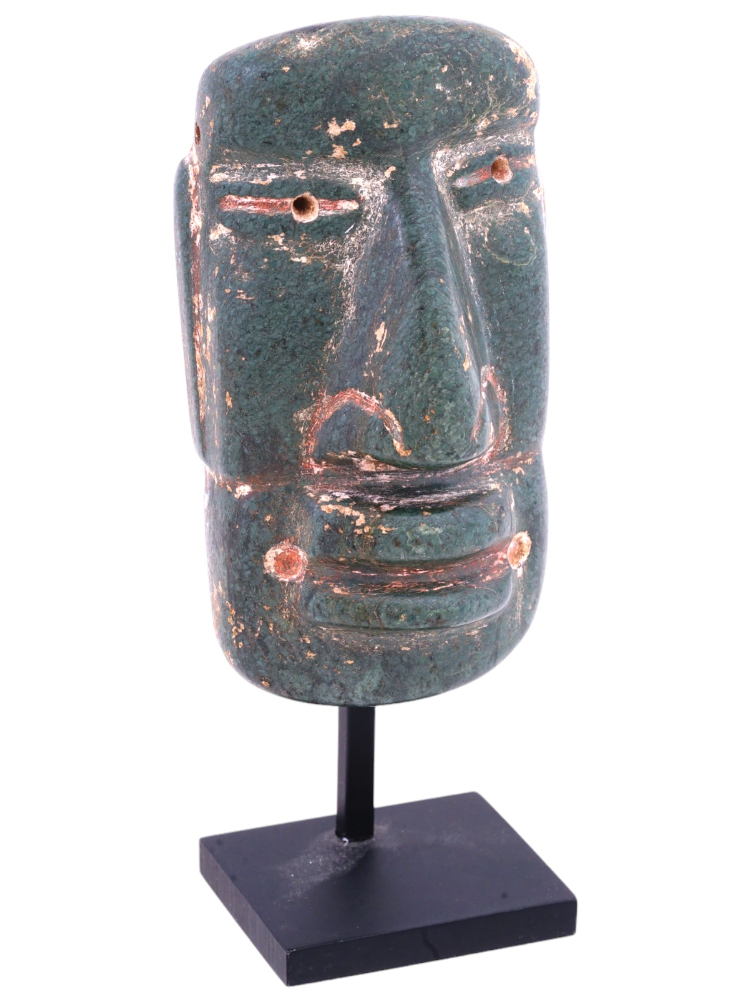 PRE COLUMBIAN AMERICA OLMEC GREEN JADE MASK: An ancient Olmec mask from Pre Columbian America made of green jade. The elongated mask has harshly carved facial features, and eyes with drilling holes in the center of the pupil of the eyes. The sam
