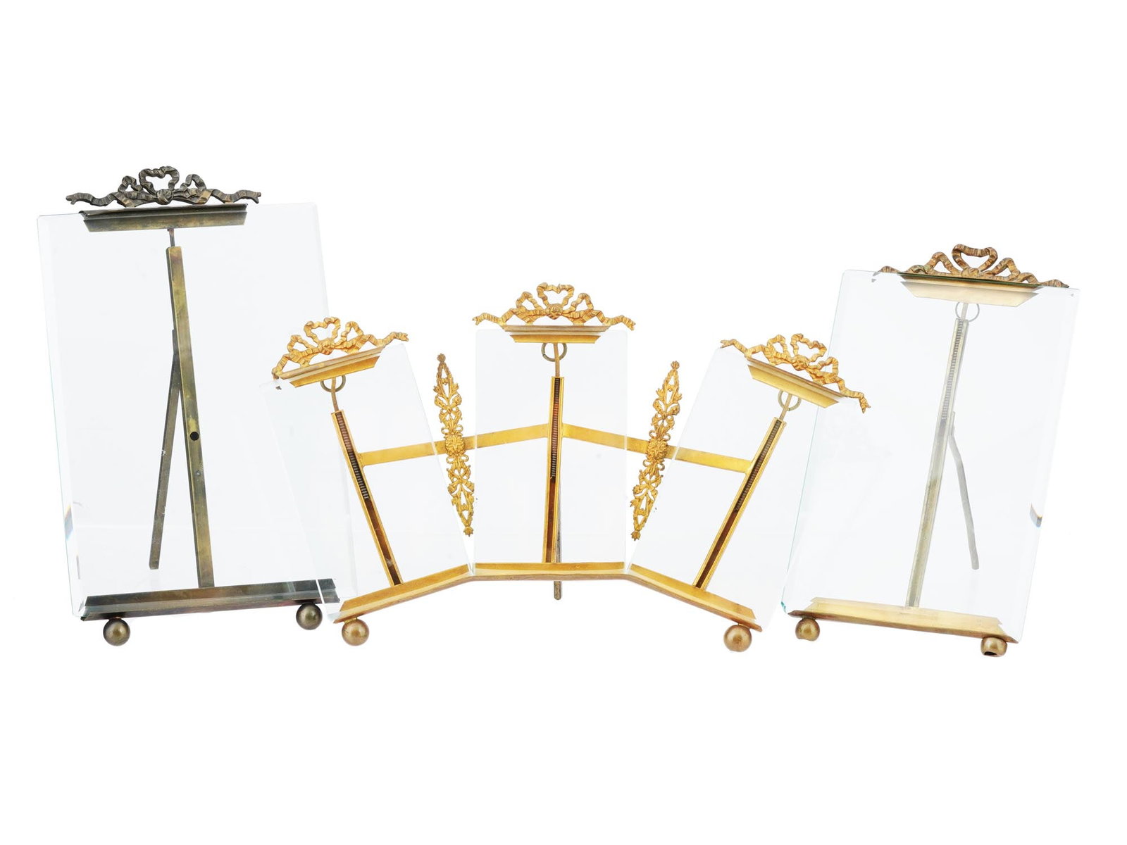 LOT OF VINTAGE EMPIRE GLASS METAL PHOTO FRAMES: A collection of gilt metal and beveled glass picture frames in the Empire taste. Includes one triple frame and two frames of a larger size adorned with ribbons on top and raised on two ball feet. Euro