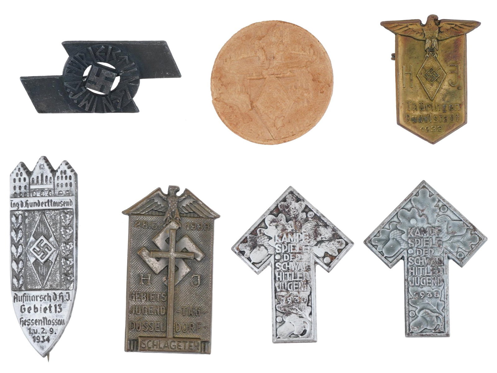 COLLECTION OF WWII NAZI GERMAN HITLER YOUTH BADGES: A collection of seven assorted WWII Nazi German Third Reich badges or tinnie. The collection includes a pair of Hitler Jugend Kampf Spiele der Schwab badges, made to commemorate the 1944 sports compet