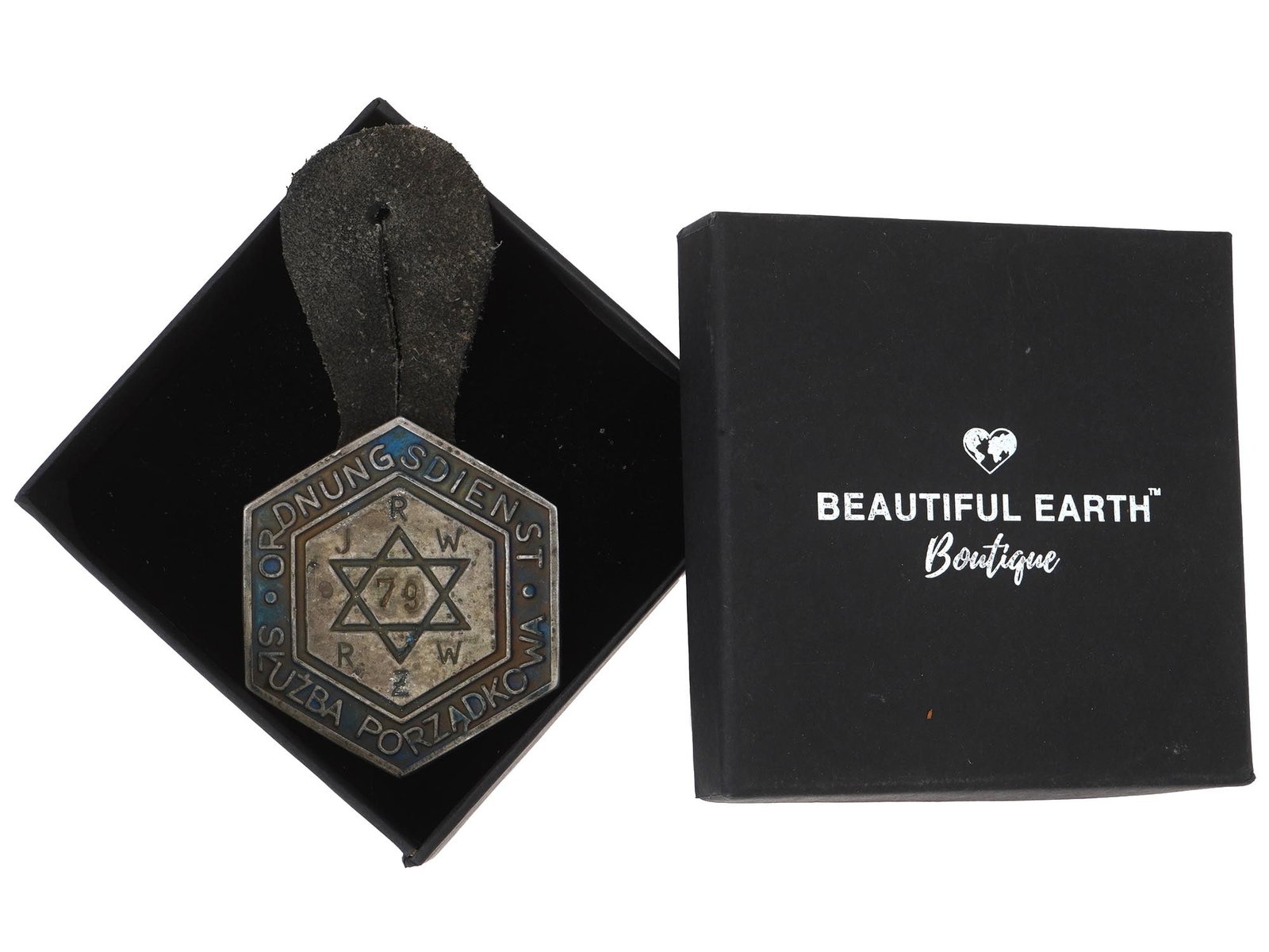 WWII MODEL WARSAW JEWISH GHETTO POLICE BADGE: A World War II type Polish metal breast badge of Warsaw ghetto police. Hexagonal badge with Magen David, inscription Ordnungsdienst Sluzba Porzadkowe, JRW RZW, 79. Leather strap. The Warsaw Ghetto was