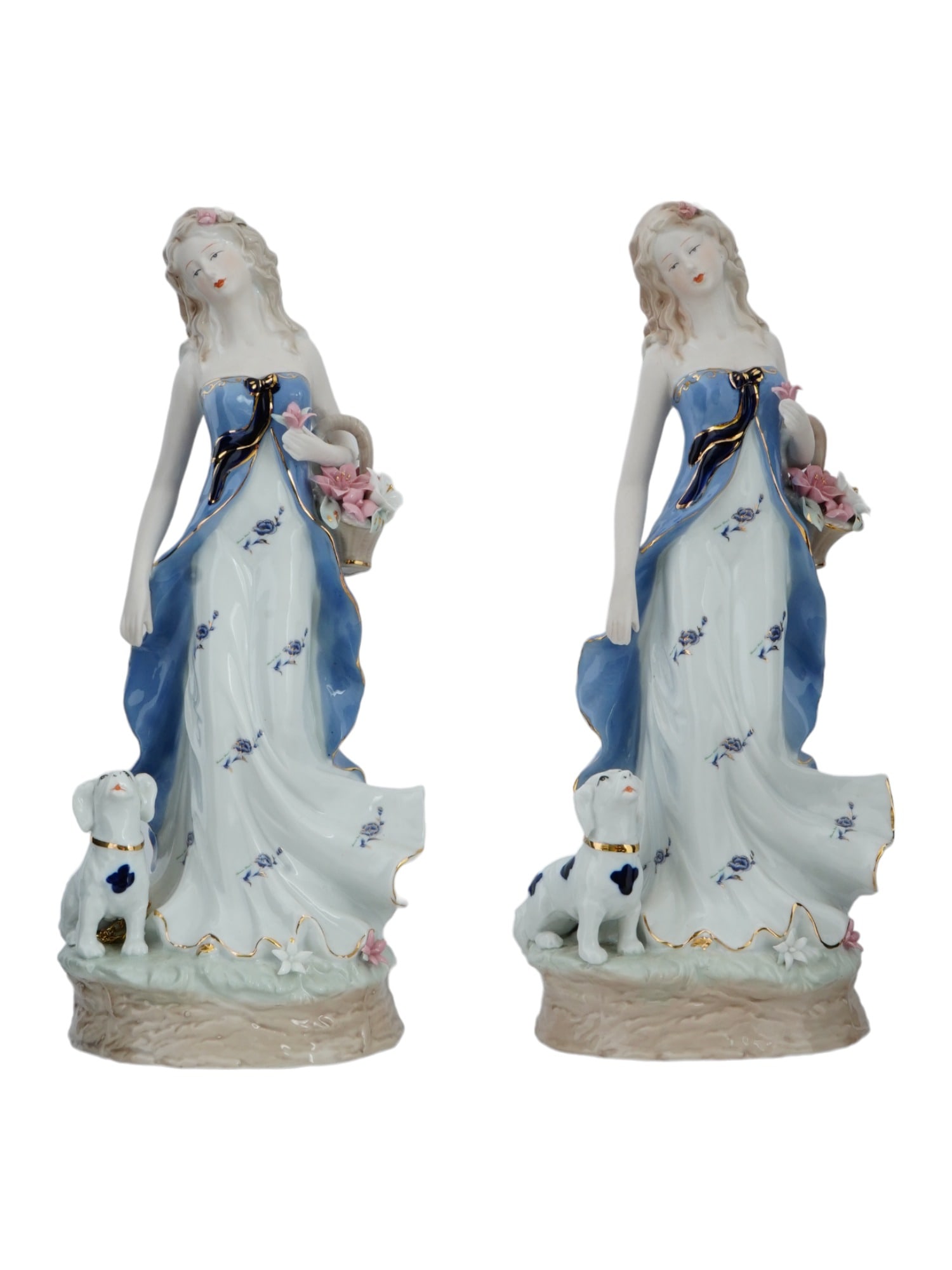 LARGE VINTAGE PORCELAIN FEMALE FIGURINES WITH DOGS: A pair of large vintage glazed porcelain figurines. Identical pieces representing a young woman in blue dress with a flower basket and a dalmatian. Gilt accents. Unmarked. Collectible Porcelain Ware A